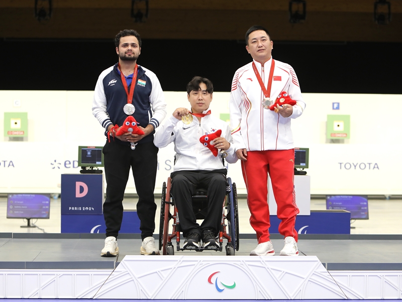 Jo Jeongdu (center) on Aug. 30 poses for photos after winning the gold in the men’s 10-m air rifle standing P1 at the Chateauroux Shooting Centre in Chateauroux, a city 270 km south of Paris.  