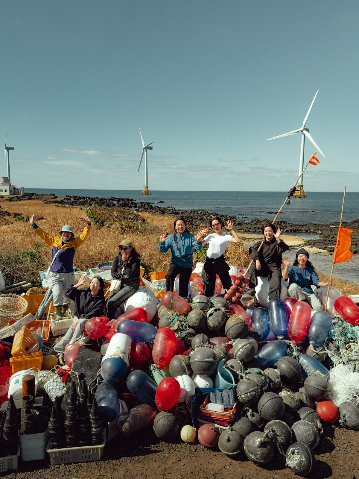 Subin Byeon (center in blue jacket) and participants pose with the trash they have collected during one of Diphda Jeju's 'bonggeuging' or plogging activities.