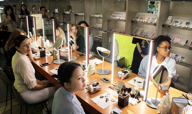 Foreign participants listen to the instructor at a Korean beauty makeup class.   