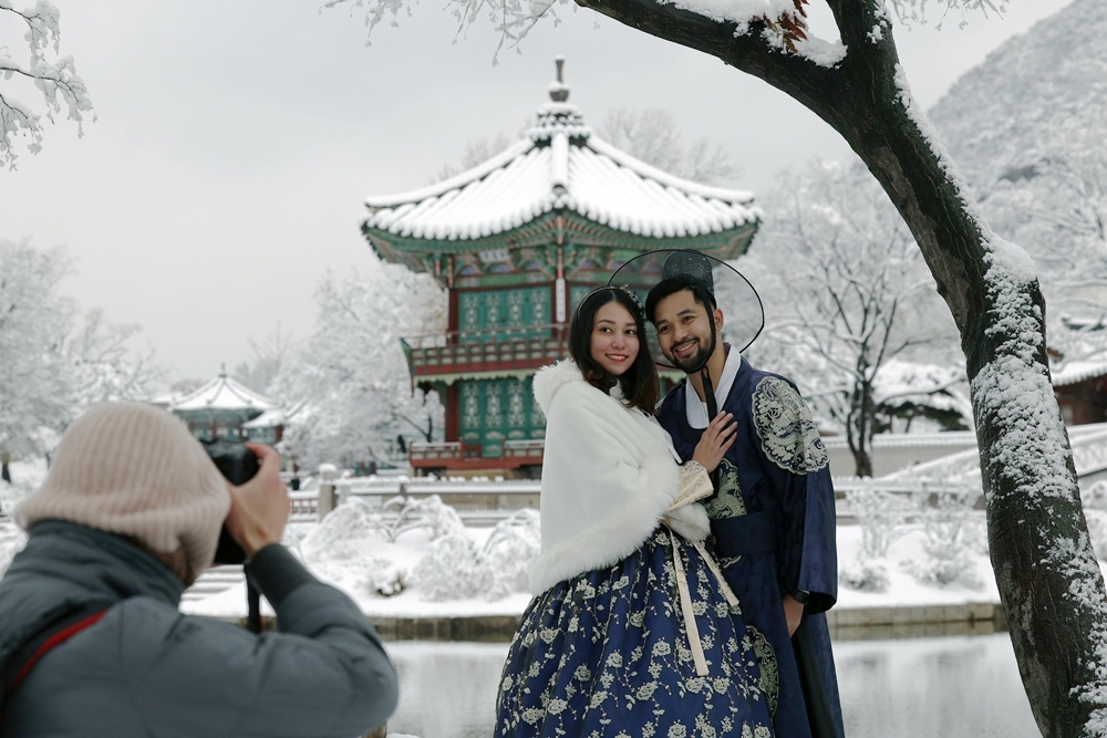  The Ministry of Justice on Dec. 11 announced the extension of the temporary exemption period for the Korea Electronic Travel Authorization, aka K-ETA, to Dec. 31 next year for nationals of the relevant countries. Shown is a foreign couple clad in Hanbok (traditional clothing) on Nov. 27 posing for photos at Gyeongbokgung Palace in Seoul's Jongno-gu District. (Lee Jun Young) 