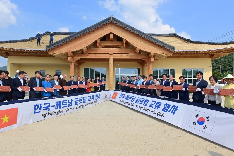 Participants of the roof-erecting ceremony for the multicultural community center of K-Vietnam Valley on Aug. 24 take a group photo at the township of Bongseong-myeon in Bonghwa-gun County, Gyeongsangbuk-do Province. (Bonghwa-gun Office)  