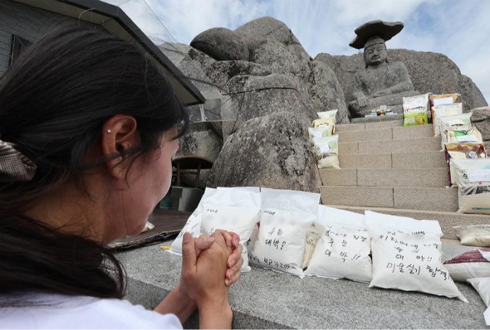 Wishing for college exam success in front of Buddha statue