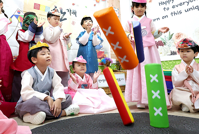 Hanbok-clad children play traditional games