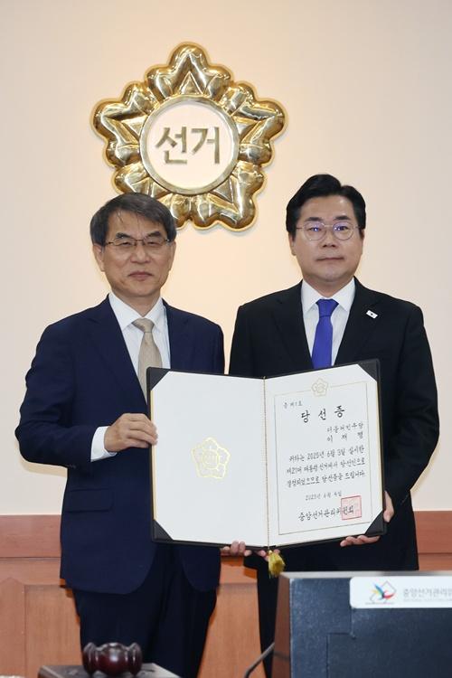 National Election Commission Chairperson Roh Tae-ak (left) on June 4 at his agency's headquarters in Gwacheon, Gyeonggi-do Province, takes a photo with Park Chan-dae, interim chairman of the Democratic Party of Korea, after giving the latter the certificate of Lee Jaemyung's election as president.  