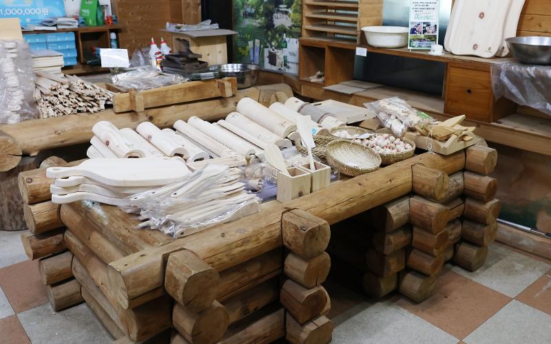 Crafts made of cypress wood are displayed at this store near National Jangseong Healing Forest. The items for sale include household items such as wooden spatulas, pillows and acupressure massage tools.