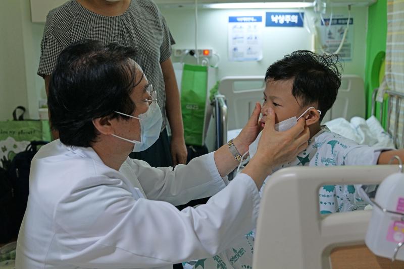 Dr. Kim Woong-Han of the Pediatric Thoracic & Cardiovascular Surgery Department at Seoul National University (SNU) Hospital on Sept. 14, 2023, examines Sai Ko Ko, a child from Myanmar who received surgery at the facility for a congenital heart defect. (SNU Hospital)